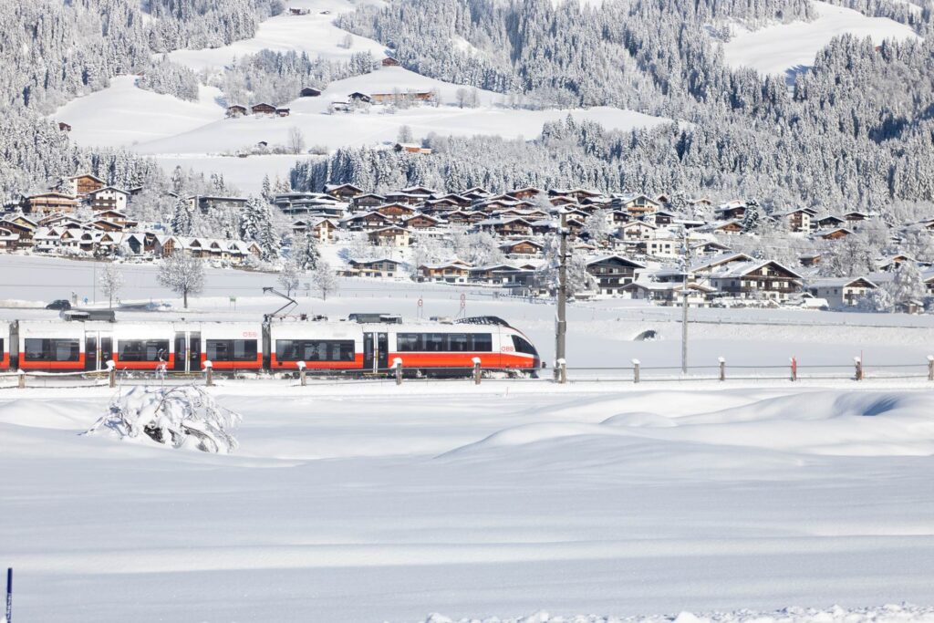 Ein Zug im winterlichen Brixental. Mit dem Zug direkt zum Skifahren in die Berge.