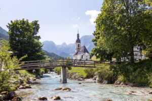 Eine kleine Kapelle in Ramsau mit einem kleinen Fluss davor. Über den Fluss geht eine kleine Brücke mit einem Gravelbike darauf.