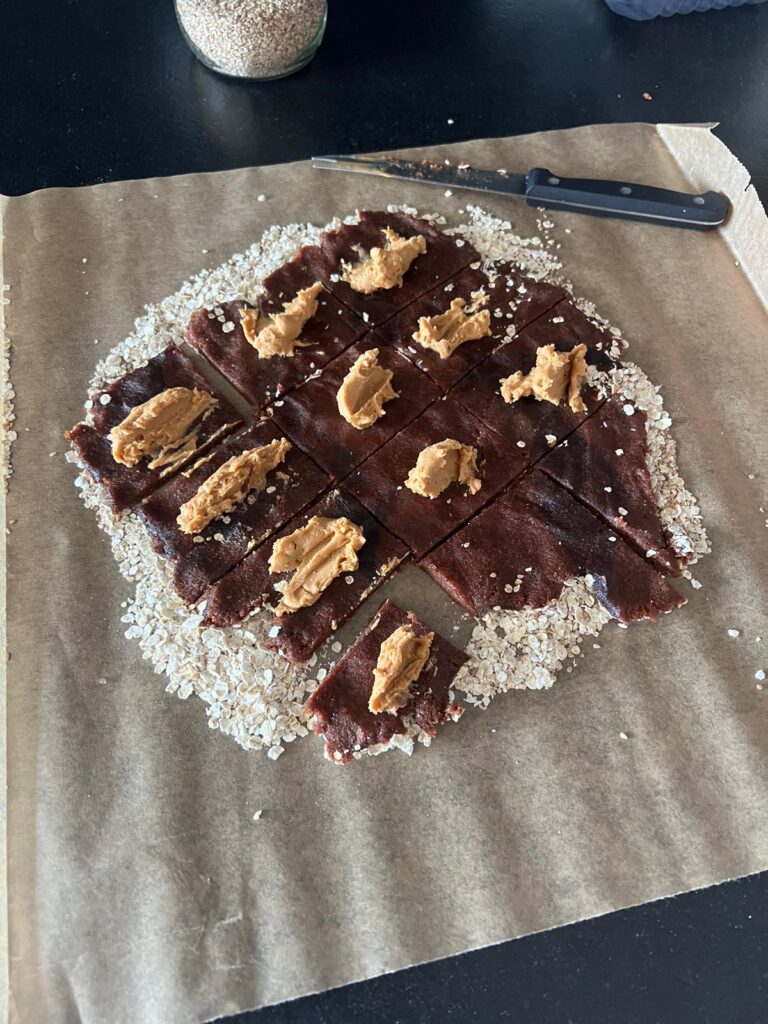 Dattel-Erdnuss-Riegel Rezept: Dattelmasse mit Erdnusbutter aufgetragen