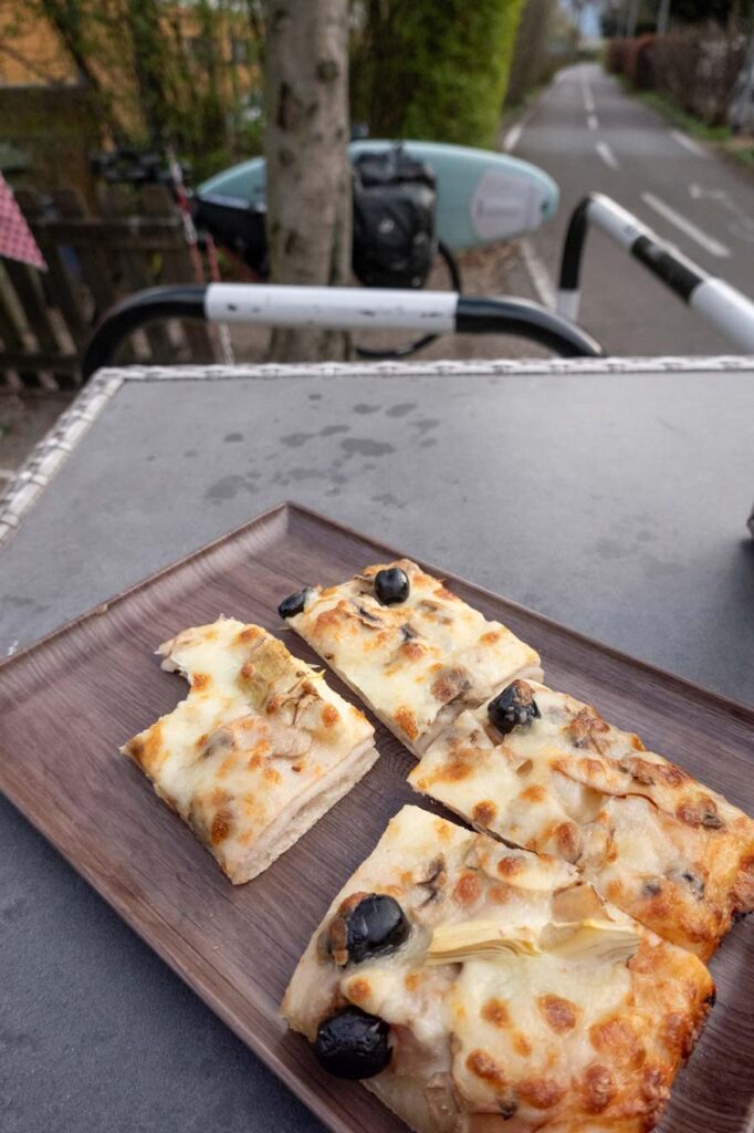 Pause in Bozen mit einer Pizza bei einer Transalptour mit dem Gravelbike.