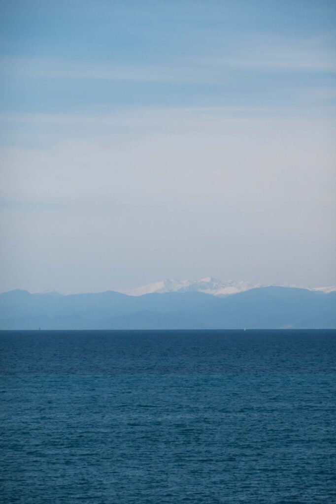 Blick auf die Riviera di Ponente von Recco aus. Die schneebedecken Alpen über dem Meer.