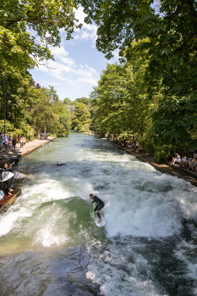 Die bekannte Eisbachwelle ist Pflicht bei einem München-Besuch mit dem Deutschland-Ticket.
