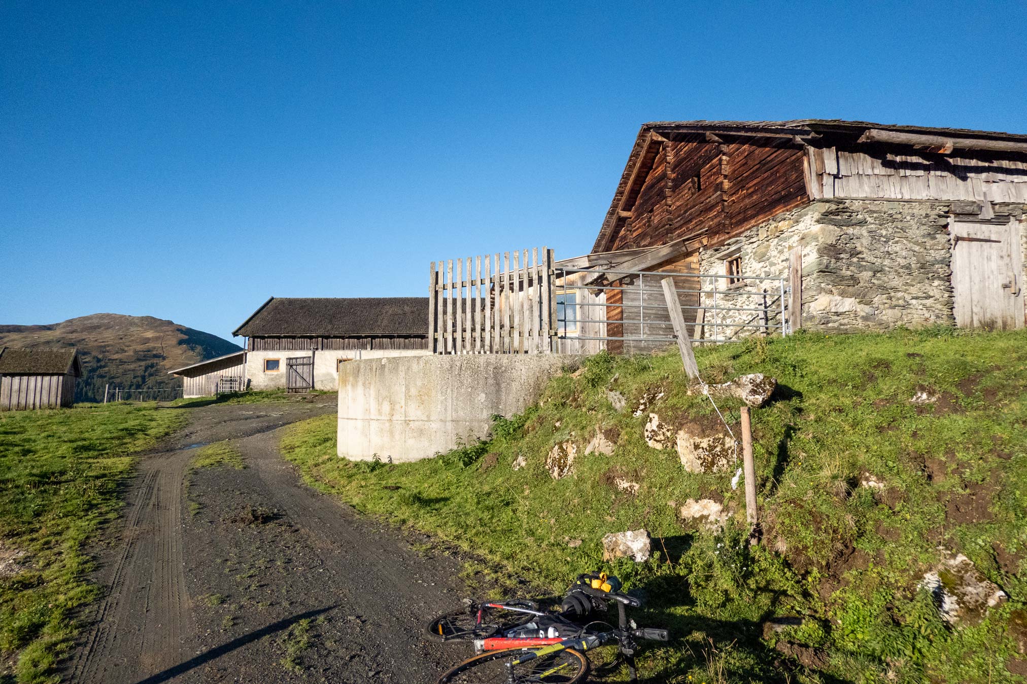 Das Stangenjoch auf Salzburger Seite mit einem Gravelbike und Almhütten.